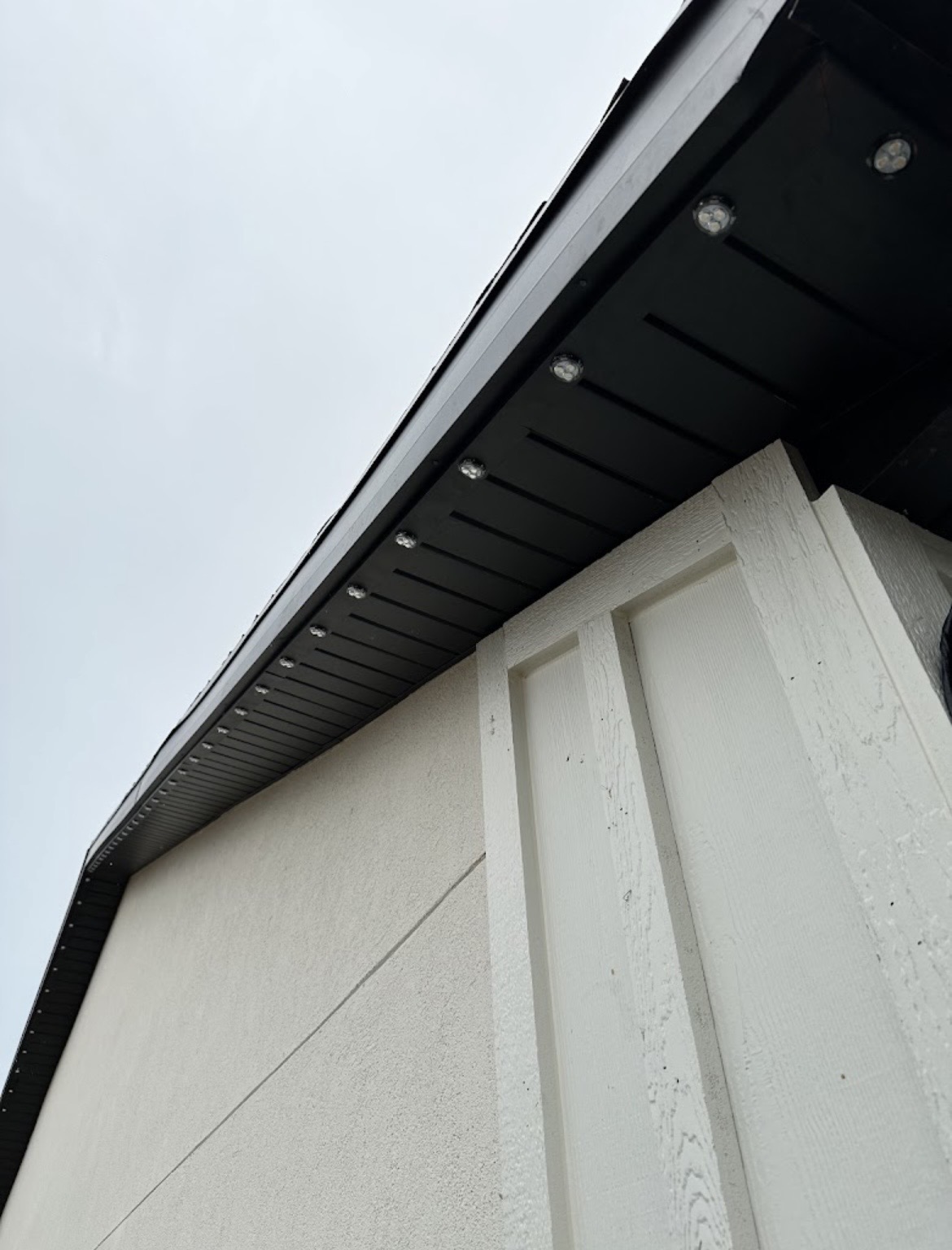 Black permanent LED track installed beneath a dark soffit