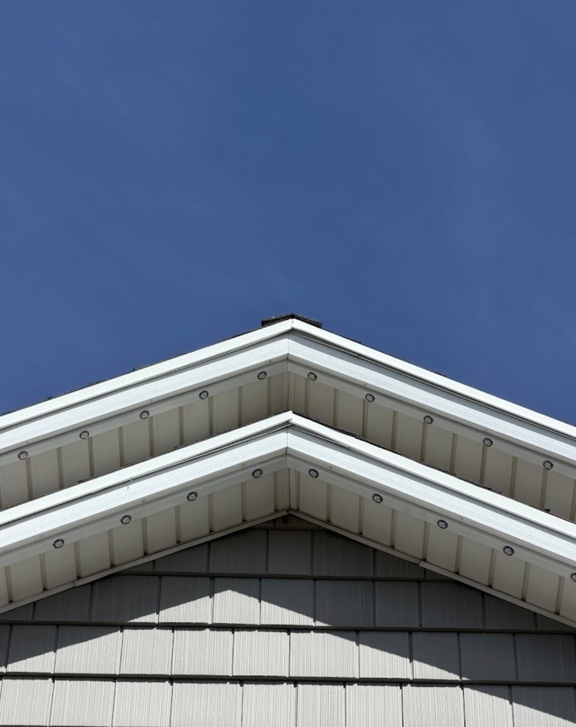 White permanent LED track installed under white soffit during daytime